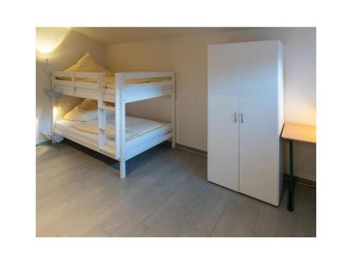 a small room with two bunk beds and a desk at Holiday apartment Möwenblick in Norden