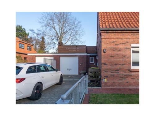 a white car parked in front of a house at Holiday apartment Möwenblick in Norden