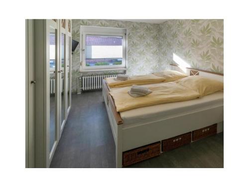 two beds in a bedroom with a window at Holiday apartment Möwenblick in Norden
