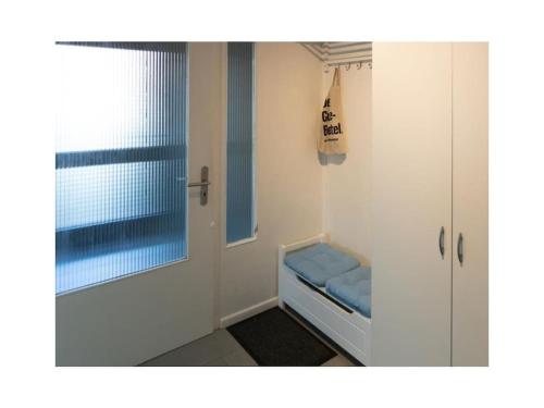 a small room with a window and a blue bench at Holiday apartment Möwenblick in Norden