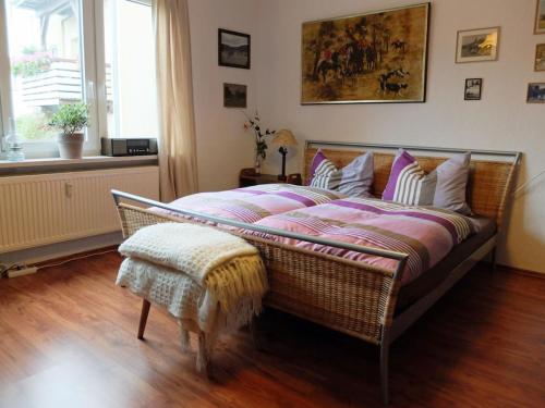 Un dormitorio con una cama de mimbre y una ventana. en Muehlenhaus Comfortable holiday residence, en Bad Harzburg