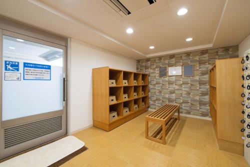 a room with a door and a chair and shelves at Tokyu Vacations Hakone Gora in Hakone