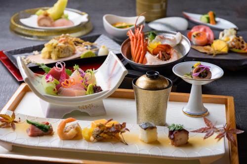 a table topped with plates of food on a table at Toba International Hotel Shiojitei in Toba