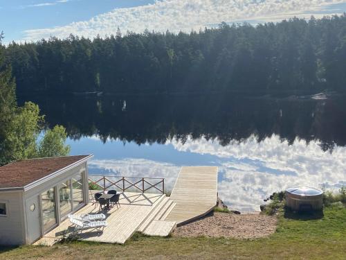 a house with a deck and a view of a lake at Awesome Home In Vena With 1 Bedrooms And Jacuzzi in Vena