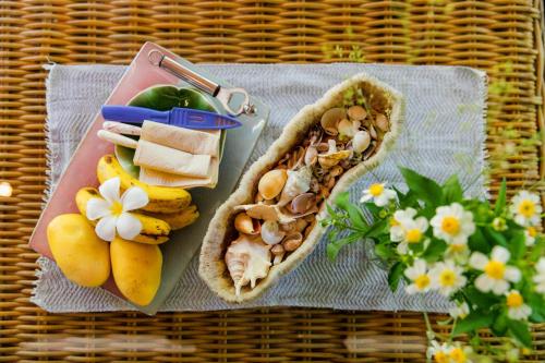 a table with a tray of food and some fruit at Mantaray Siargao in General Luna