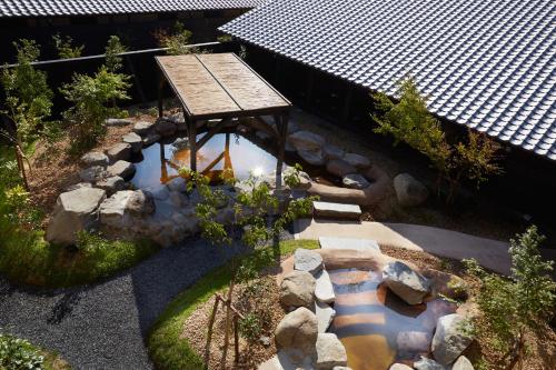 an overhead view of a garden with a table and a pond at i + Land Nagasaki in Nagasaki