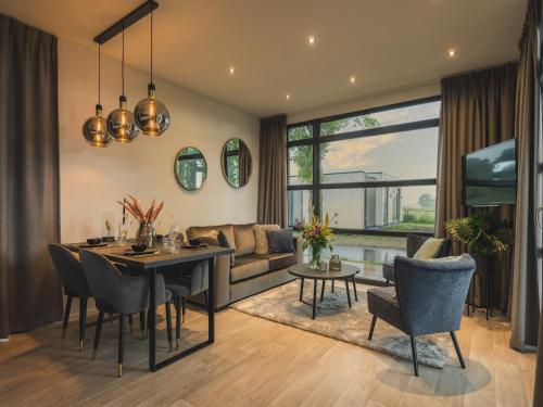 a living room with a table and a couch at Cozy Riverside Escape in Maurik