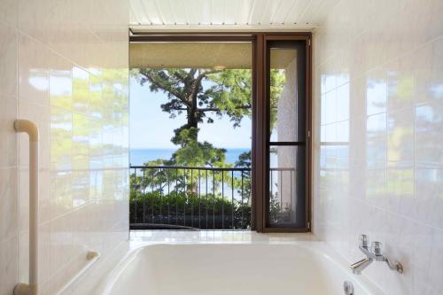 a bath tub in a bathroom with a window at Tokyu Vacations Izuimaihama in Kawazu