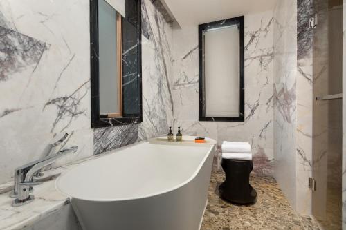 a white bathroom with a tub and a mirror at Hotel Indigo Guangzhou Haixinsha by IHG - Free Shuttle Bus to Canton Fair Complex during Canton Fair period in Guangzhou
