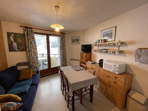 un salon avec un canapé bleu et une table dans l'établissement Confortable T2 avec balcon au cœur de la station, proche pistes et commerces - FR-1-787-80, à Laveissière