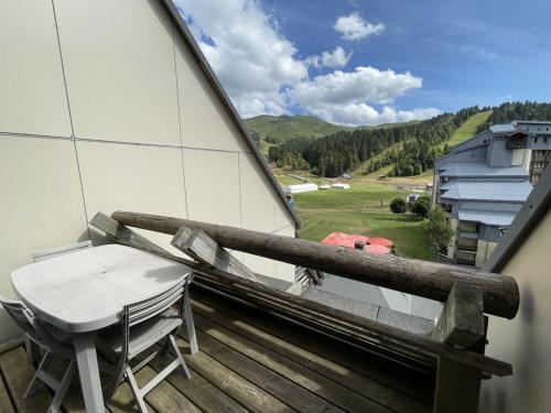 d'une table et d'une chaise sur un balcon avec vue. dans l'établissement Duplex cosy 6-8 pers. pieds des pistes avec balcon - FR-1-787-88, à Laveissière