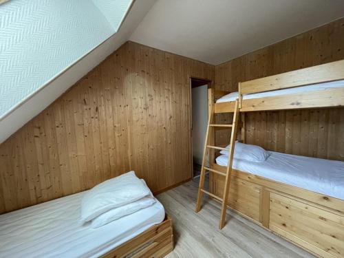 une chambre avec deux lits superposés et une échelle dans l'établissement Duplex cosy 6-8 pers. pieds des pistes avec balcon - FR-1-787-88, à Laveissière