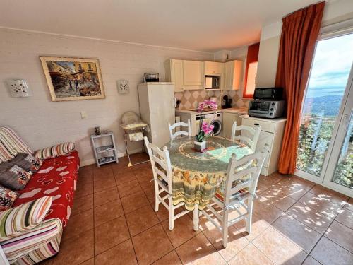 une cuisine avec une table et des chaises dans une pièce dans l'établissement Appartement climatisé avec piscine et animaux admis - FR-1-768-104, à Roquebrune-sur Argens