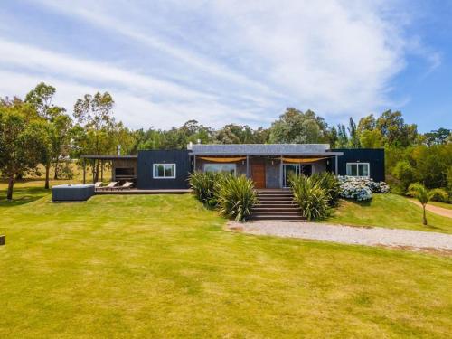 a modern house with a green yard at Casa 5 dormitorios in Balneario Buenos Aires