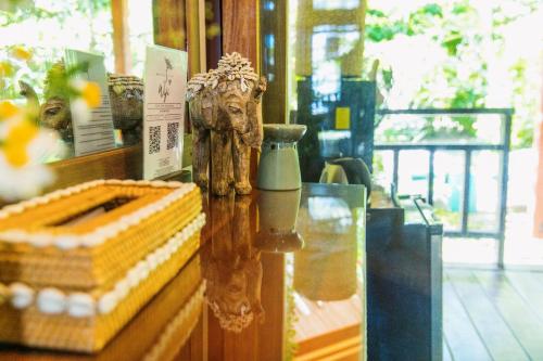 a glass table with a statue on top of it at Mantaray Siargao in General Luna