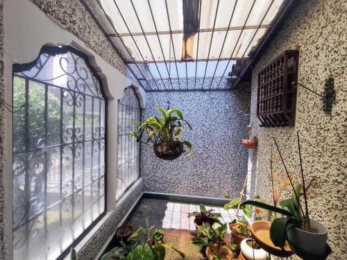 a room with a balcony with plants and a window at Habitación 2 en Casa Retro in Medellín