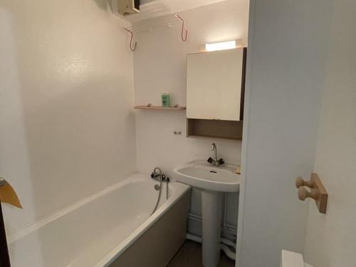 une salle de bain blanche avec un lavabo et une baignoire dans l'établissement Charmant T2 au Lioran avec accès direct aux pistes et animaux admis - FR-1-787-90, à Laveissière