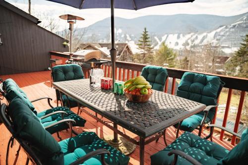 a table with a bowl of fruit on a balcony at Hunter Haven - Luxury Cabin Near Mountain Ski Resort in Lanesville