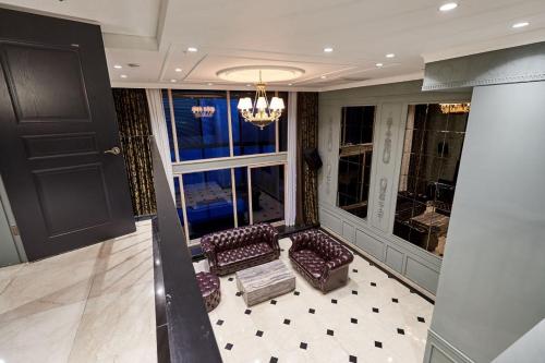 a living room with two chairs and a chandelier at Suwon Partyz Hotel in Suwon
