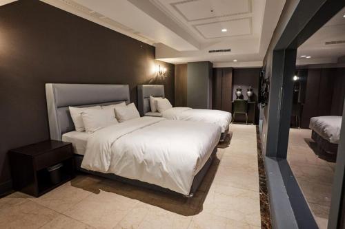 a bedroom with two beds with white sheets at Suwon Partyz Hotel in Suwon