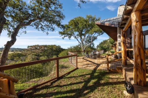 a view from the porch of a house with a fence at Guadalupe Bluff Log Cabin in Kerrville
