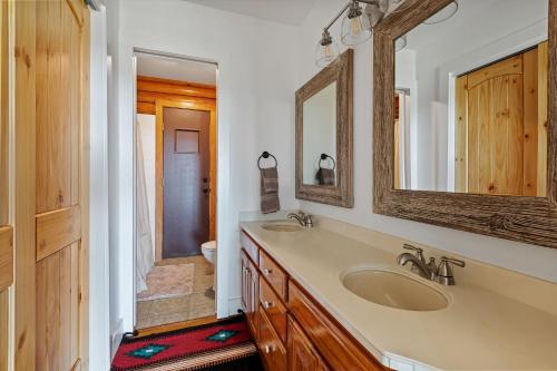 a bathroom with a sink and a mirror at Guadalupe Bluff Log Cabin in Kerrville