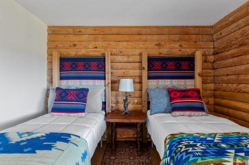 two beds sitting next to each other in a room at Guadalupe Bluff Log Cabin in Kerrville