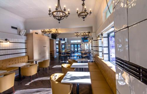 a dining room with tables and chairs in a restaurant at Royal Hotel Randwick in Sydney