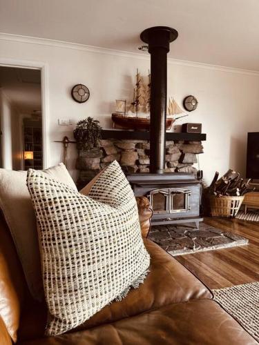 a living room with a couch and a fireplace at The Gums - Bruny Island in Woodbridge