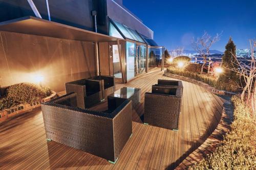a building with a deck with wicker furniture on it at Suwon Partyz Hotel in Suwon