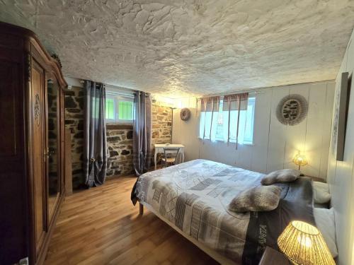 ein Schlafzimmer mit einem Bett und einer Steinwand in der Unterkunft Maison au cœur du Périgord avec grand jardin - FR-1-616-78 in Saint-Jory-de-Chaleix