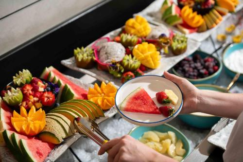 a person holding a magnifying glass over a table of fruit at Atura Adelaide Airport in Adelaide