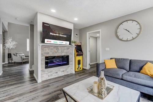 a living room with a couch and a clock on the wall at Hearth Haven - Hot Tub BBQ Large Groups in Colorado Springs