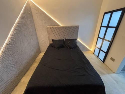 a bed with black sheets and pillows in a room at Apartamento en ubicación central in Arauca