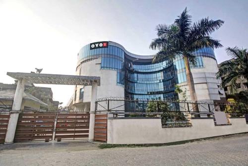 a building with a palm tree in front of it at Super Collection O Hotel Aqua Villa Near Netaji Subhash Chandra Bose International Airport in Kolkata