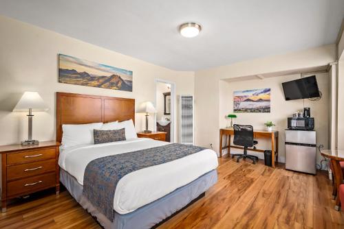 a hotel room with a large bed and a desk at Sunbeam Motel in San Luis Obispo