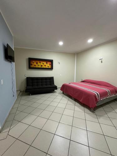 a bedroom with a bed and a couch in it at Casa Eva in Tepoztlán