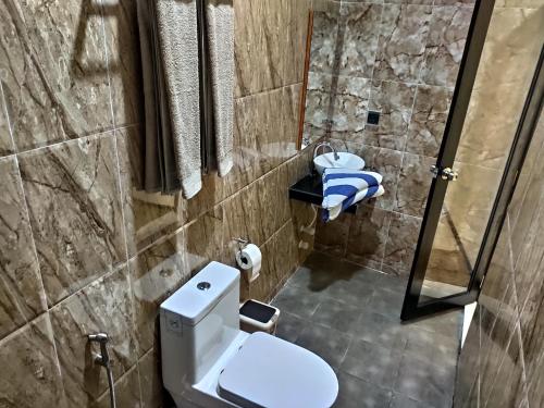une petite salle de bain avec toilettes et douche dans l'établissement Crown Beach Family villas, à Dhiffushi