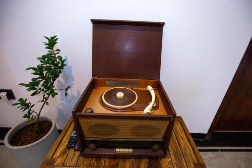 una vieja radio sentada en una mesa con una planta en Sleeperwood Villa, en Unawatuna