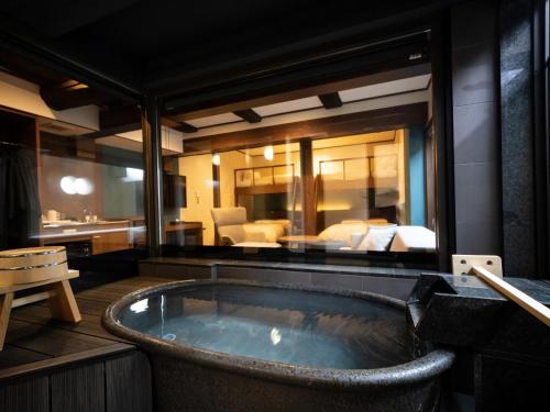 - une baignoire dans une chambre dans l'établissement Gensen Ichinoyu, à Kusatsu