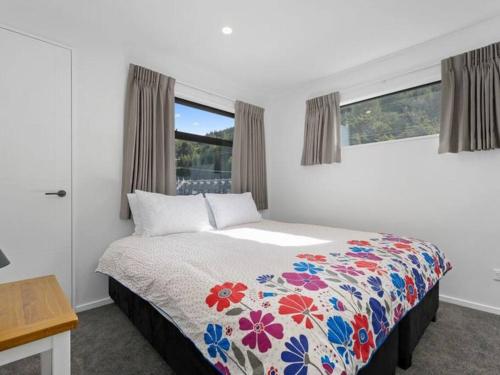 フランクトンにあるQueenstown Luxury Holiday Villaのベッドルーム1室(花柄のベッドカバー付)