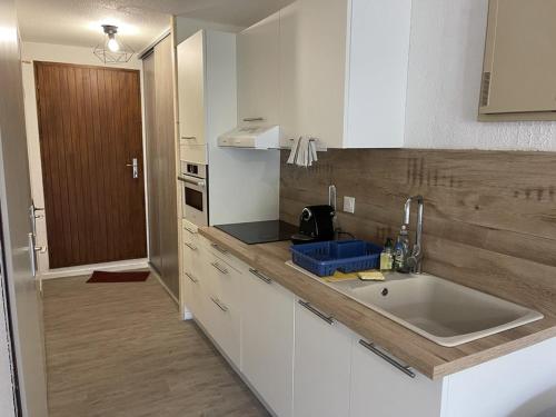 une cuisine avec un évier et un plan de travail dans l'établissement Charmant T2 au Lioran avec accès direct aux pistes et animaux admis - FR-1-787-90, à Laveissière