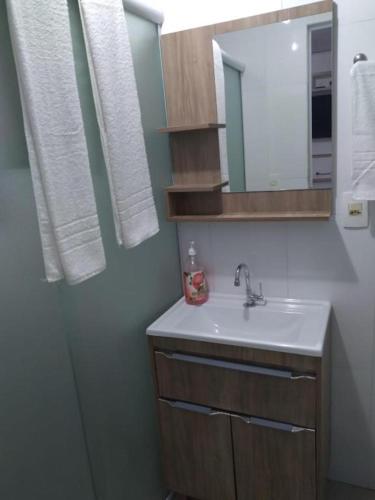 a bathroom with a sink and a mirror at Casa na Praia Araçá in Bombas