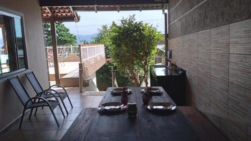 a wooden table and chairs on a patio at Casa na Praia Araçá in Bombas