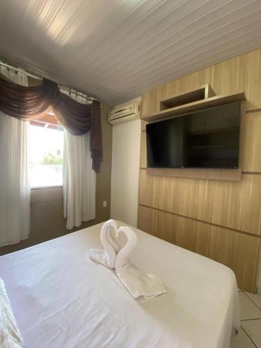 a room with a bed with a heart shaped towel at Casa na Praia Araçá in Bombas