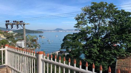 a white fence with a view of the water at Casa na Praia Araçá in Bombas
