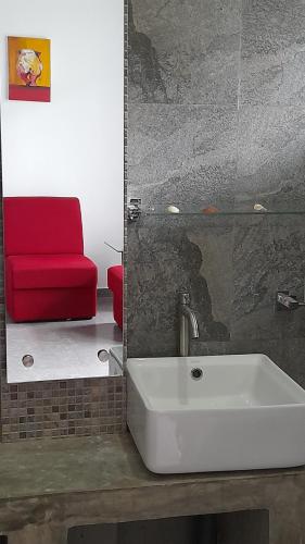 a bathroom with a sink and a red chair at SriMany in Mirissa