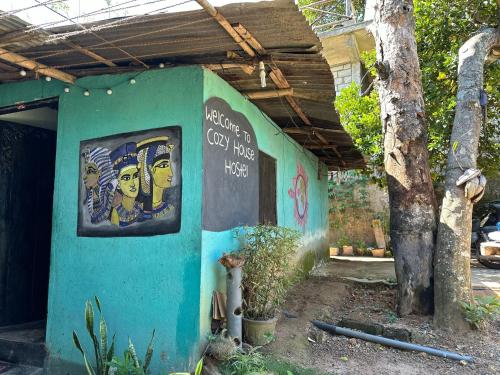 a blue building with a sign on the side of it at Cozy House Hostel in Ella
