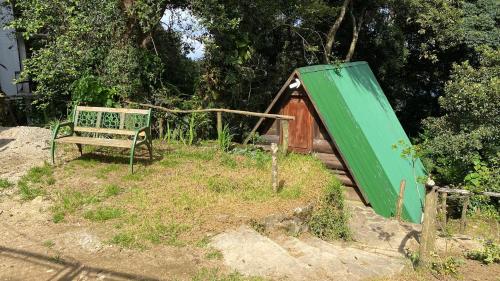 a green tent and a bench in a yard at Cabañita del bosque de la cumbre de san Bartolo Milpas Altas in Guatemala