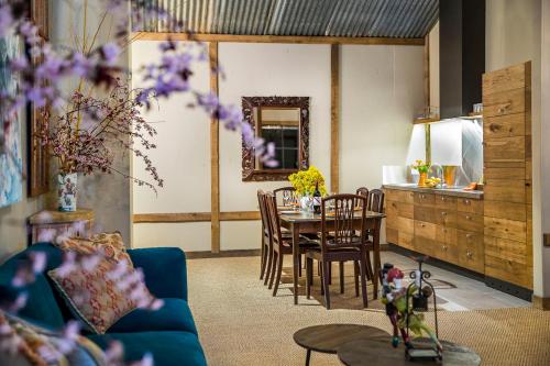 a living room with a blue couch and a table at AL RU Farm in Sampsons Flat